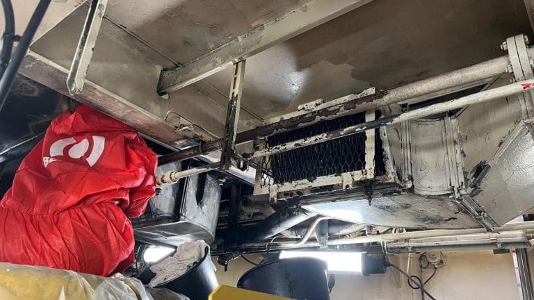 BELFOR worker in an engine room of a ship covered in soot after a fire