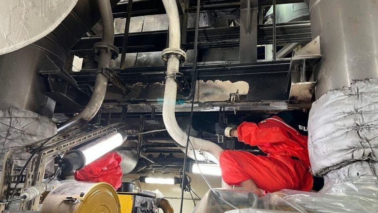 BELFOR worker in an engine room of a ship covered in soot after a fire